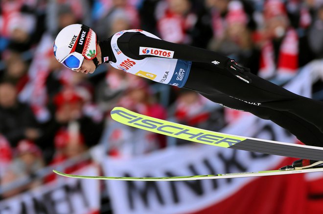 Kamil Stoch je pred več 10.000 navijači z rdeče-belimi zastavami na skakalnici Wielka Krokiew spet dobil krila in poletel do zmage. FOTO: Reuters