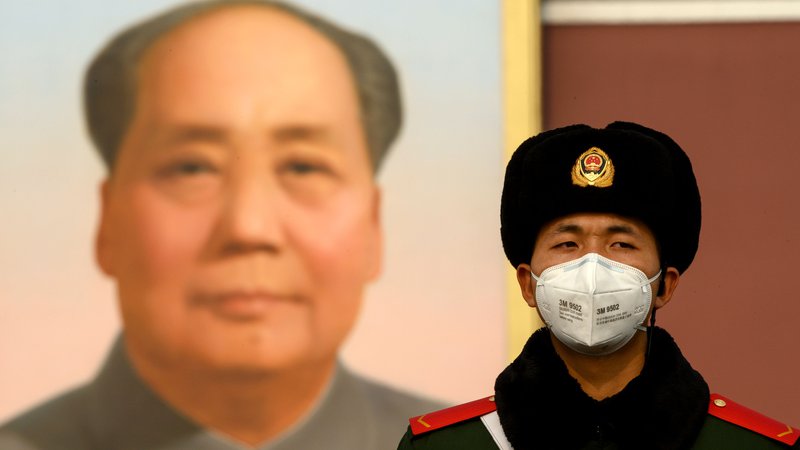 Fotografija: Nošenje maske je obvezno tudi za stražarja pred portretom Maa Zedonga v Pekingu. FOTO: Noel Celis/AFP