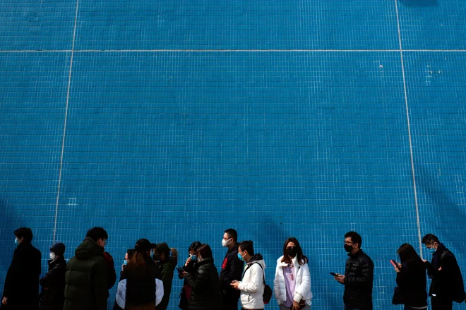 Vrste za nakup zaščitnih mask v Hongkongu. FOTO: Tyrone Siu/Reuters