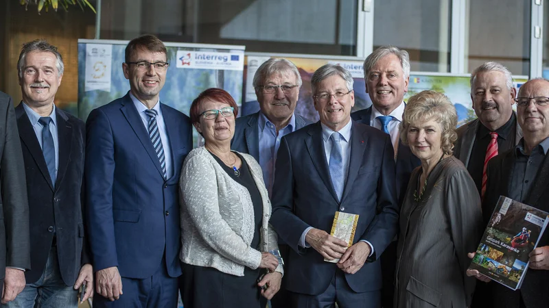 Fotografija: V geoparku sodeluje 9 avstrijskih in 5 slovenskih občina. Z leve: Erich Pachler (podžupan občine Lavamünd/Labot), Jakob Strauß (Sittersdorf/Žitara vas), Franz Josef Smrtnik (Bad Eisenkappel/Železna Kapla), Tomaž Rožen (Ravne na Koroškem), Romana Lesjak (Črna na Koroškem), Stefan Visotschnig (Bleiburg/Pliberk), Peter Kaiser (koroški deželni glavar), Gerhard Visotschnig (Neuhaus/Suha), Marijana Cigala (Dravograd), Hermann Srienz (Feistritz ob Bleiburg/Bistrica nad Pliberkom), Dušan Krebel (Mežica), Bernhard Sadovnik (Globasnitz/Globasnica), Matic Tasič (Prevalje), Hannes Mak (Gallizien/Galicija), Heribert Kulmesch (Zell/Sele). FOTO:Urosh Grabner