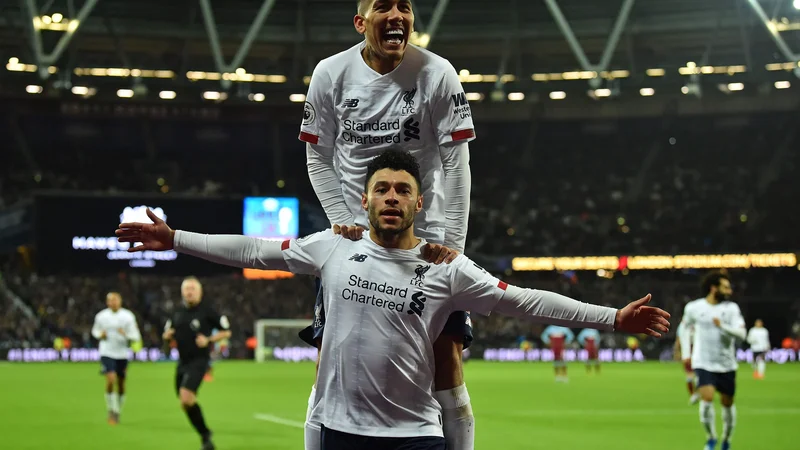 Fotografija: Brazilski napadalec Roberto Firmino je takole naskočil soigralca Alexa Oxlade-Chamberlaina, potem ko je slednji postavil končni izid 2:0. FOTO: AFP
 