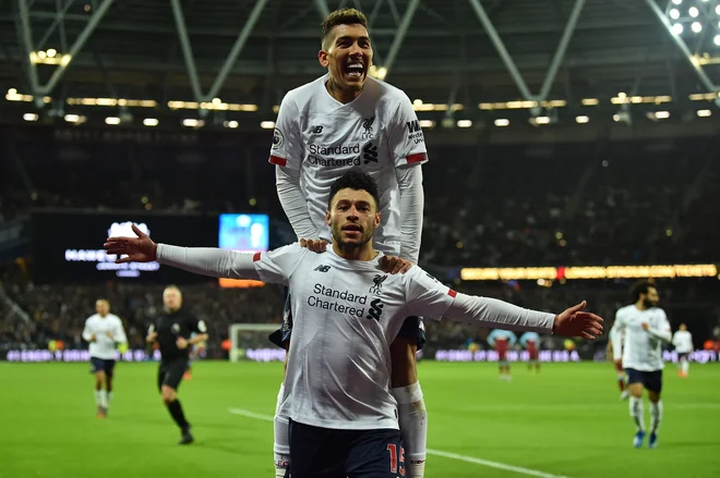 Brazilski napadalec Roberto Firmino je takole naskočil soigralca Alexa Oxlade-Chamberlaina, potem ko je slednji postavil končni izid 2:0. FOTO: AFP<br />
&nbsp;