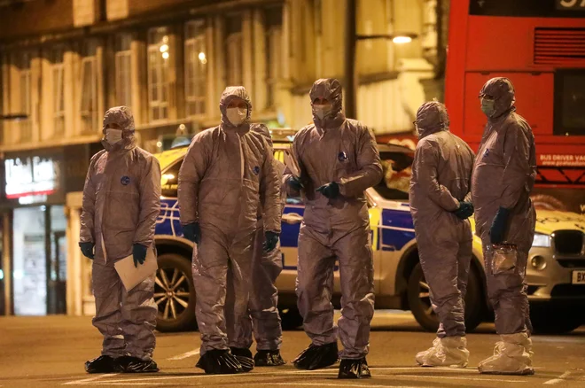 Forenziki so dolgo preiskovali kraj napada. FOTO: Simon Dawson/ Reuters