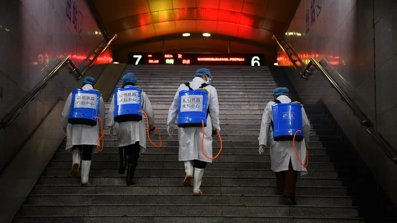 Zdravstveni delavci razkužujejo železniško postajo v mestu Kunming. FOTO: Reuters