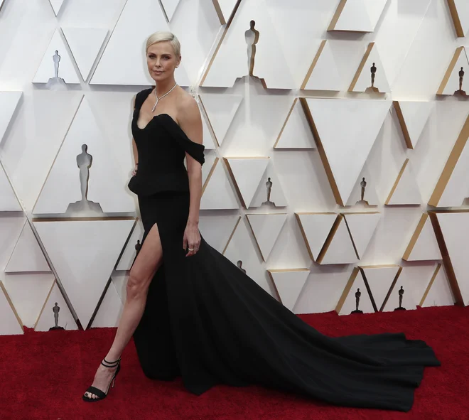 Charlize Theron pozira na rdeči preprogi. FOTO: Eric Gaillard/Reuters