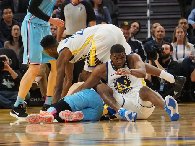 Gorana Dragića (na tleh) sta domača košarkarja Kevon Looney (spodaj) in Andrew Wiggins ustavljala tudi z rokoborskimi prijemi. FOTO: Usa Today Sports
