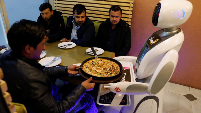 Fotografija: Medtem ko na Japonskem in Kitajskem roboti postajajo nekaj običajnega, to ne velja za v vojni opustošeni Afganistan. Po desetletjih vojne, v kateri je bila uničena večina infrastrukture v državi, robotska natakarica ponuja nekaj razvedrila. FOTO: Mohammad Ismail/Reuters