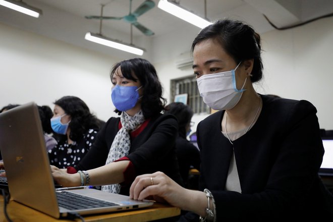 Učitelji na Kitajskem nosijo zaščitne maske. FOTO: Kham Reuters
