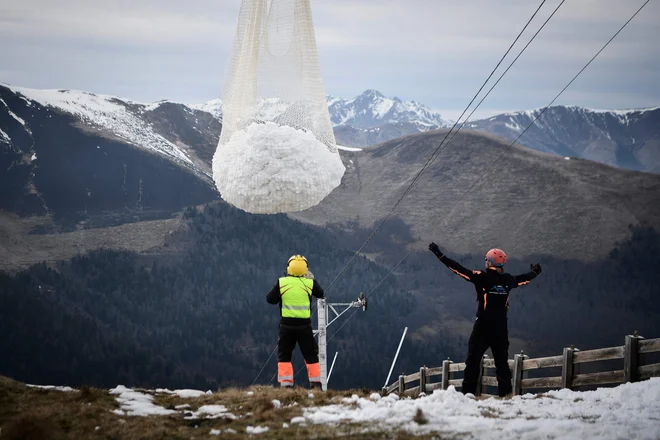 Na smučišče Luchon-Superbagneres v francoskih Pirenejih dovažaj sneg s helikopterjem z višjih območij. FOTO: Anne-Christine Poujoulat/AFP