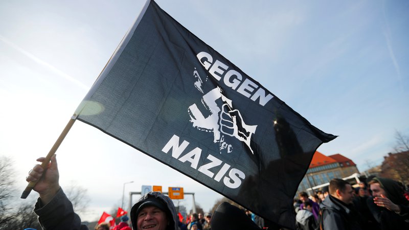 Fotografija: Protestnik z zastavo 'proti nacistom'. FOTO: Hannibal Hanschke/Reuters