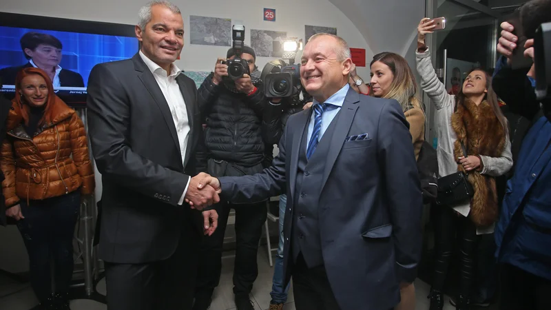Fotografija: Franc Kangler in Aleksander Saša Arsenovič si čestitata ob uvrstitvi v drugi krog. FOT: Tadej Regent/Delo