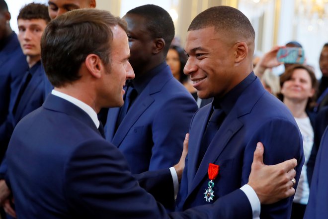 Emmanuel Macron in Kylian Mbappe med torkovim podeljevanjem posebnih priznanj svetovnim prvakom iz Rusije 2018. FOTO: AFP