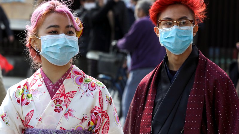 Fotografija: Turisti z maskami v japonski prestolnici. FOTO: Athit Perawongmetha/Reuters