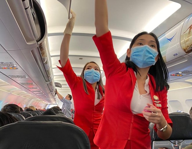 Stevardese letalske družbe AirAsia imajo zaščitne maske. FOTO: Gašper Mlakar