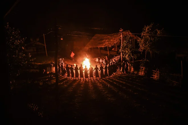 Članice plemena Gongwang Bonyo, ki so med najbolj izoliranimi skupnostmi v Burmi, med celonočnim obredom plešejo ob tabornem ognju, da bi blagoslovili prihodnjo letino. FOTO: Ye Aung Thu/Afp<br />
