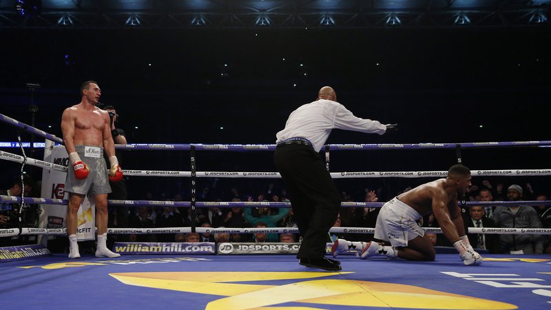 Fotografija: Ukrajinski boksarski šampion Vladimir Kličko (levo) je takole pred dvema letoma v šesti rundi poslal na tla britanskega zvezdnika Anthonyja Joshuo. FOTO: Reuters