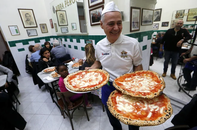 Na fotografiji je upodobljena neapeljska picerija L'Antica Pizzeria da Michele, v kateri so snemali filmsko uspešnico <em>Jej, moli, ljubi</em> z Julio Roberts v glavni vlogi. FOTO: Ciro De Luca/Reuters