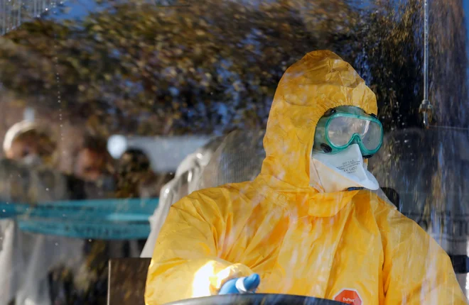 Osebje, ki je sprejelo potnike, je nosilo zaščitne obleke. FOTO: Reuters