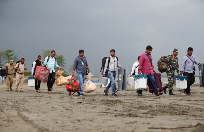 Elektronske volilne naprave utirajo pot na volišča v okrožju Jorhat v indijski zvezni državi Asam. Parlamentarne volitve bodo trajale do 19. maja. FOTO: Reuters