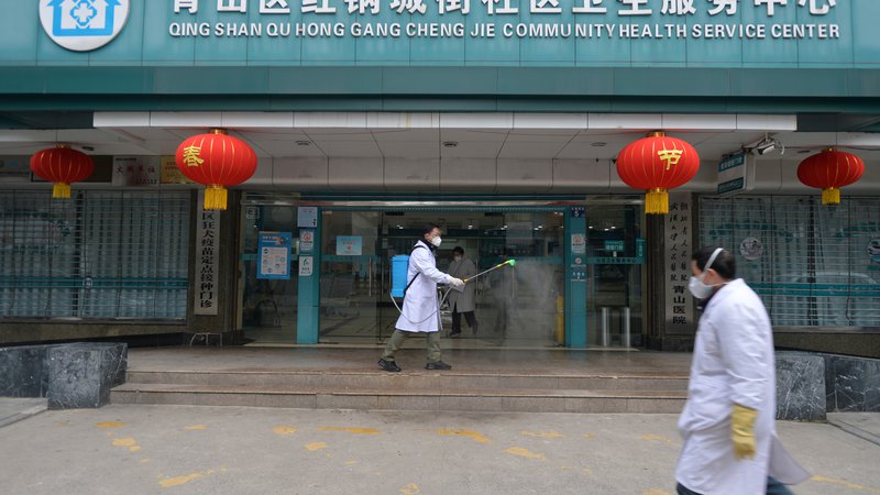 Fotografija: Delavec dezinficira vhod v bolnišnico v Wuhanu. FOTO: Reuters