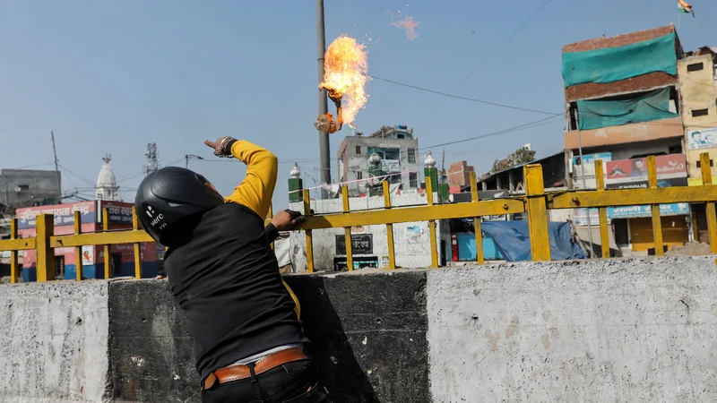 Fotografija: Podpornik Modijeve skrajne hindujske stranke meče bencinsko bombo na muslimansko svetišče. FOTO: Danish Siddiqui/Reuters