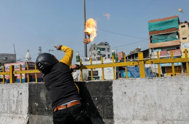 Podpornik Modijeve skrajne hindujske stranke meče bencinsko bombo na muslimansko svetišče. FOTO: Danish Siddiqui/Reuters