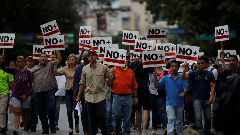 Fotografija: »Nič več diktature,« so na svoje plakate zapisali udeleženci sredinih protestov proti vladi Nicolása Madura. FOTO: Carlos Barria/Reuters