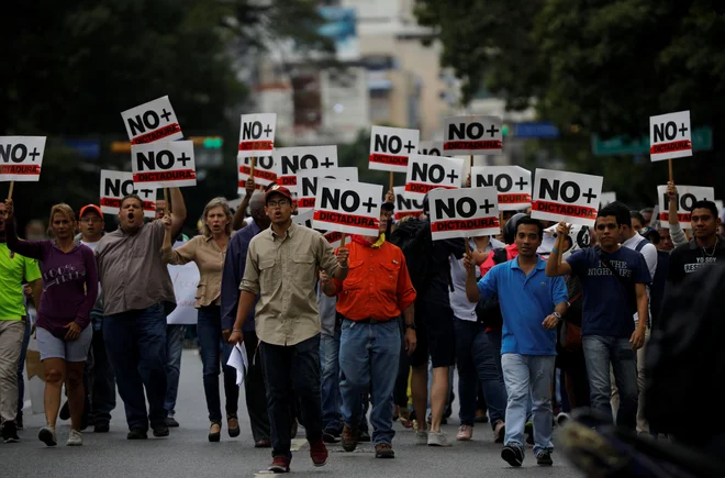 &raquo;Nič več diktature,&laquo; so na svoje plakate zapisali udeleženci sredinih protestov proti vladi Nicolása Madura. FOTO: Carlos Barria/Reuters