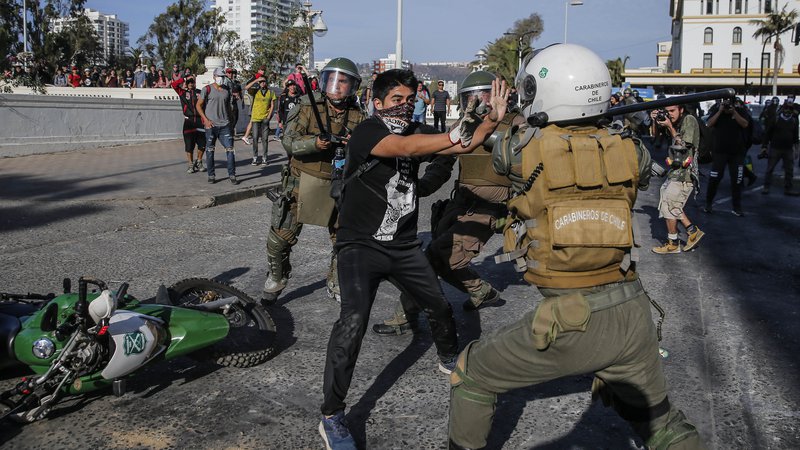 Fotografija: Protivladni protesti v Čilu se nadaljujejo tudi letos. Na fotografiji spopad policista in protestnika v letovišču Vina del Mar. FOTO: Javier Torres/AFP