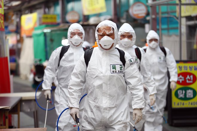 Po svetu je za boleznijo umrlo več kot 3000 ljudi, v Južni Koreji so potrdili še 599 novih primerov okužbe. FOTO: Afp