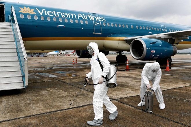 Vietnamci razkužujejo prispela letala. FOTO: Nhac Nguyen/AFP