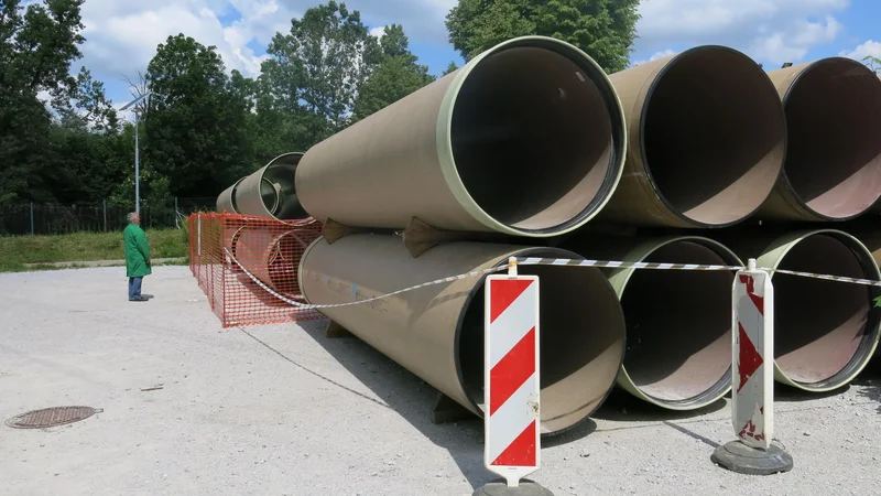 Fotografija: Kar 1200-milimetrske kanalizacijske cevi čakajo, da jih vgradijo v zemljo na Ljubljanskem polju. FOTO: Janez Petkovšek