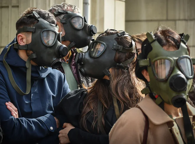 Pred ministrstvom za okolje v Bukarešti več sto protestnikov, ki nosijo plinske maske, zahteva boljši zrak, saj se v Romuniji soočajo z visokim onesnaženjem zraka. FOTO: Daniel Mihailescu/Afp<br />
&nbsp;