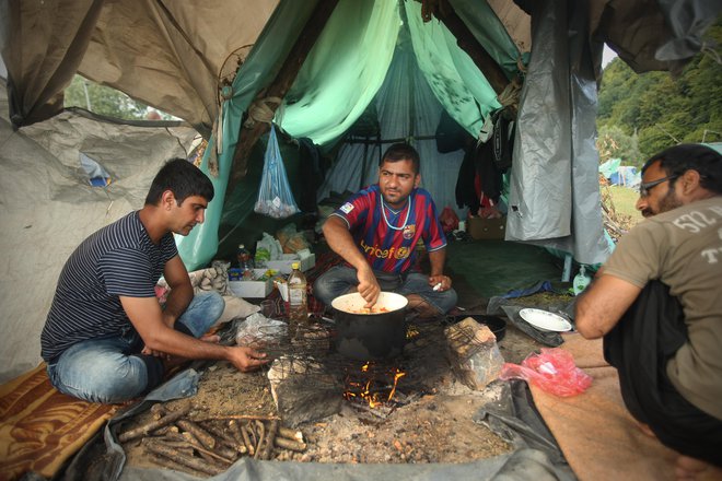 Pakistanski migranti kuhajo večerjo v improviziranem kampu na obrobju mesta. FOTO: Jure Eržen/Delo
