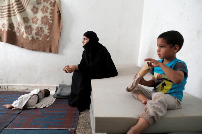 Žena in otroci nekdanjega pripadnika Islamske države v taborišču v Siriji. FOTO: Zohra Bensemra/Reuters