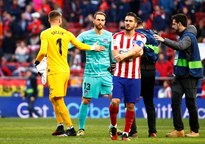 Pozdrav slovanskih vratarjev: Čeh Tomaš Vaclik (v rumenem) je branil vrata Seville, Slovenec Jan Oblak vrata madridskega Atletica. Razšla sta se s prijateljskim izidom 2:2. FOTO: Reuters