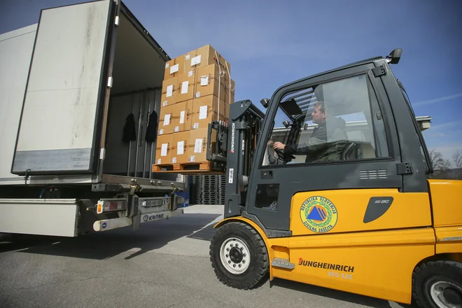 V paketih za Grčijo je 9000 odej, 1500 parov gumijastih škornjev, 500 spalnih vreč in 30.000 pelerin za enkratno uporabo. FOTO: Jože Suhadolnik/Delo