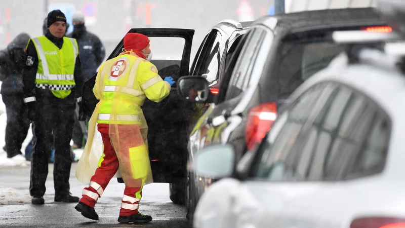 Fotografija: Medicinsko osebje na prelazu Brenner med merjenjem temperature voznikom, ki prihajajo iz Italije. FOTO: Andreas Gebert/Reuters