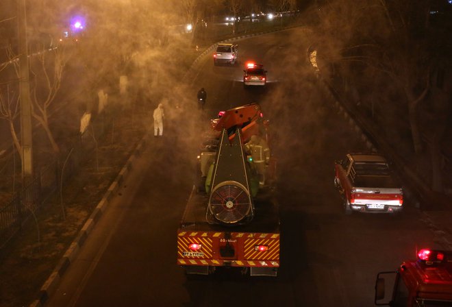 V Iranu gasilci ponoči razkužujejo mestne ulice. FOTO: Atta Kenare/AFP