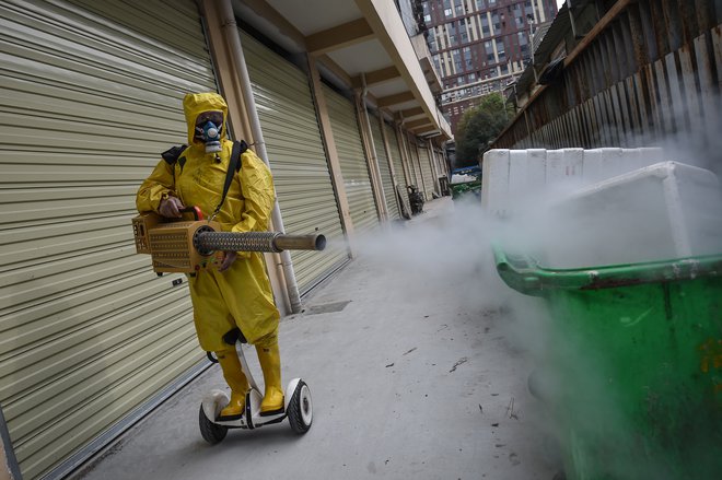 Ulice razkužujejo tudi v mestu Wuhan na Kitajskem, kjer se je virus prvič pojavil. FOTO: AFP