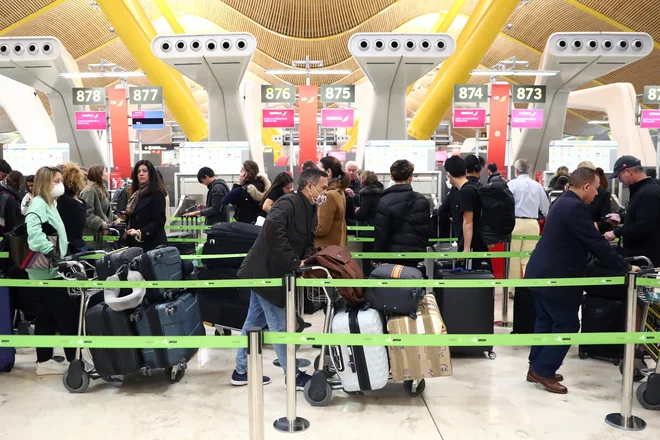 Potniki, namenjeni v ZDA, med čakanjem na madridskem letališču Barajas. FOTO: Sergio Perez/Reuters