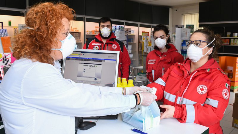 Fotografija: Prostovoljci Rdečega križa kupujejo zdravila za prebivalce kraja Castiglione della Pescaia, ki ne morejo zapustiti svojih domov. Foto Reuters