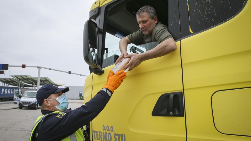 Fotografija: Večina voznikov tovornjakov je po štirih dneh čakanja prvič dobila vodo in sendviče ki jih deli slovenska Policija. Mejni prehod Obrežje 13.3.2020. FOTO: Jože Suhadolnik/Delo