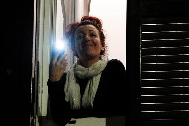 Italijani so k petju in muziciranju na balkonih dodali še prižiganje lučk. Dvigovanje morale z akcijo Razsvetlimo Italijo. FOTO: Guglielmo Mangiapane/Reuters