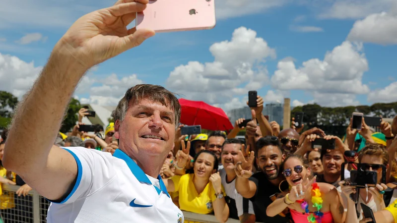 Fotografija: Brazilski predsednik Jair Bolsonaro se je včeraj družil s svojimi podporniki. FOTO: Sergio Lima/AFP