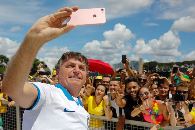 Brazilski predsednik Jair Bolsonaro se je včeraj družil s svojimi podporniki. FOTO: Sergio Lima/AFP