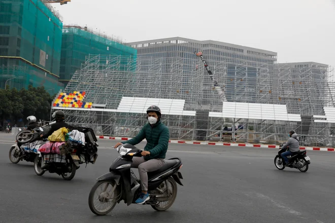 V Vietnamu, ki naj bi kmalu gostil prvo dirko formule 1, se po stezi vozijo ljudje v maskah. FOTO: Reuters