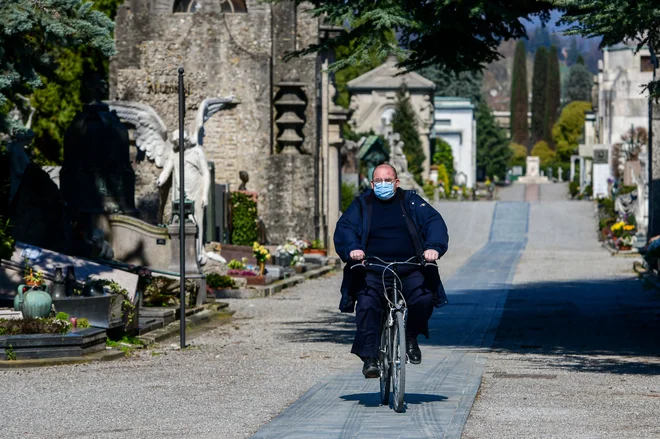 Delavec na pokopališču v Bergamu, kjer se pogrebi umrlih zaradi bolezni covid-19 vrstijo na vsake pol ure. FOTO: Piero Cruciatti/AFP