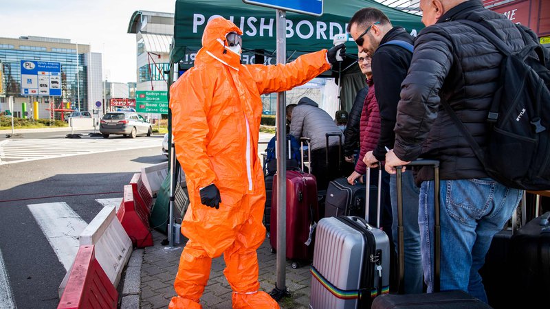 Fotografija: Strožji režim je na notranjih in zunanjih schengenskih mejah. Na fotografiji poljski zdravstveni delavec meri telesno temperaturo potnikom na meji z Nemčijo. FOTO: Odd Andersen/AFP