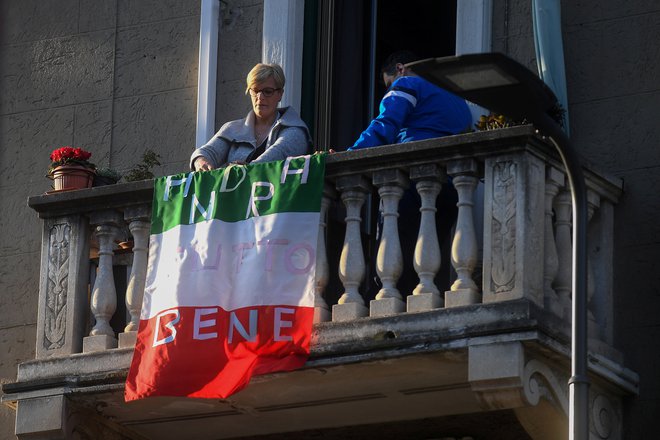Vse bo še dobro, je zapisano na zastavi na enem izmed milanskih balkonov. FOTO: Daniele Mascolo/Reuters